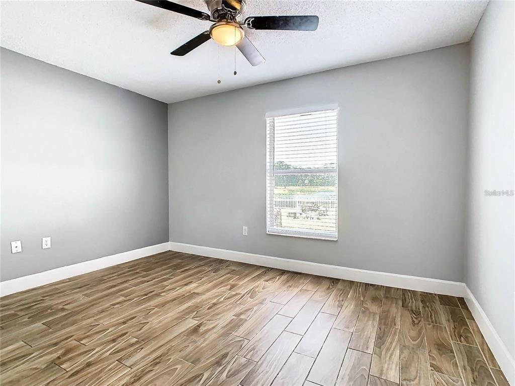 3194 Windmill Point Boulevard Kissimmee, FL 34746 - Photo 18 of 32 wooden floor in an empty room with a window