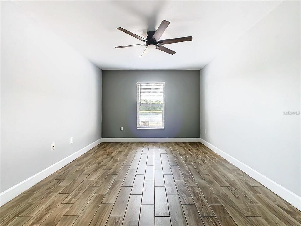 3194 Windmill Point Boulevard Kissimmee, FL 34746 - Photo 19 of 32 wooden floor in an empty room with a window
