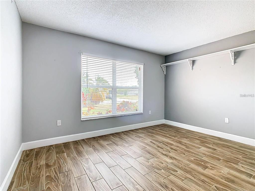 3194 Windmill Point Boulevard Kissimmee, FL 34746 - Photo 29 of 32 a view of an empty room with a window and wooden floor