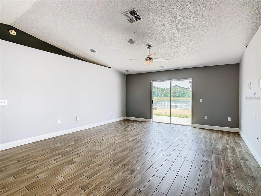 3194 Windmill Point Boulevard Kissimmee, FL 34746 - Photo 6 of 32 a view of an empty room with wooden floor and a window