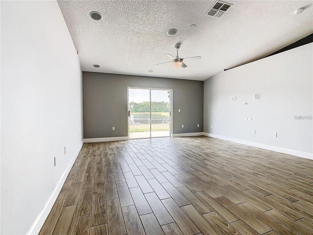 3194 Windmill Point Boulevard Kissimmee, FL 34746 - Photo 7 of 32 an empty room with wooden floor and windows