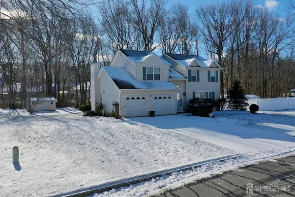 a front view of a house with a yard covered with snow in front of house