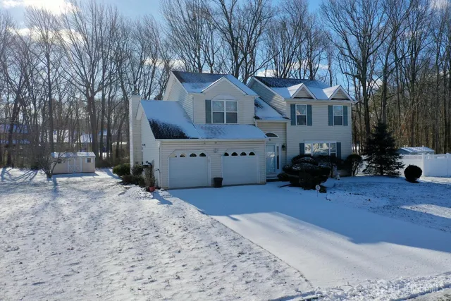 a front view of a house with a yard covered in snow