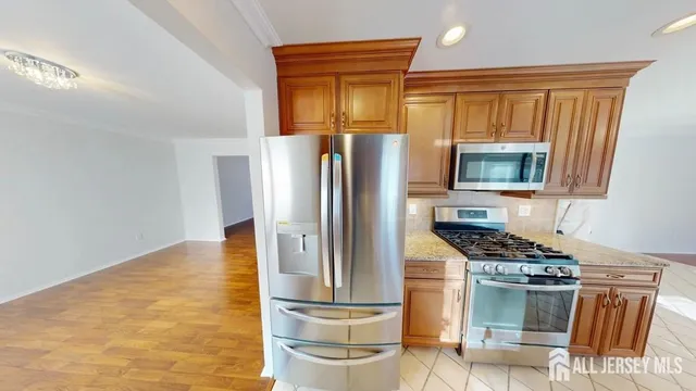 a kitchen with stainless steel appliances granite countertop a refrigerator and a stove top oven