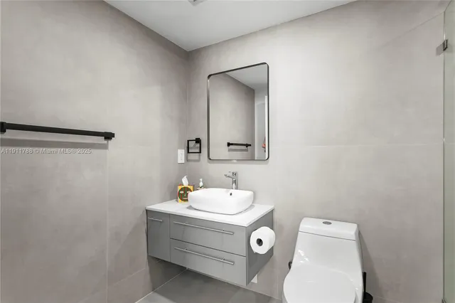 a bathroom with a sink toilet and mirror