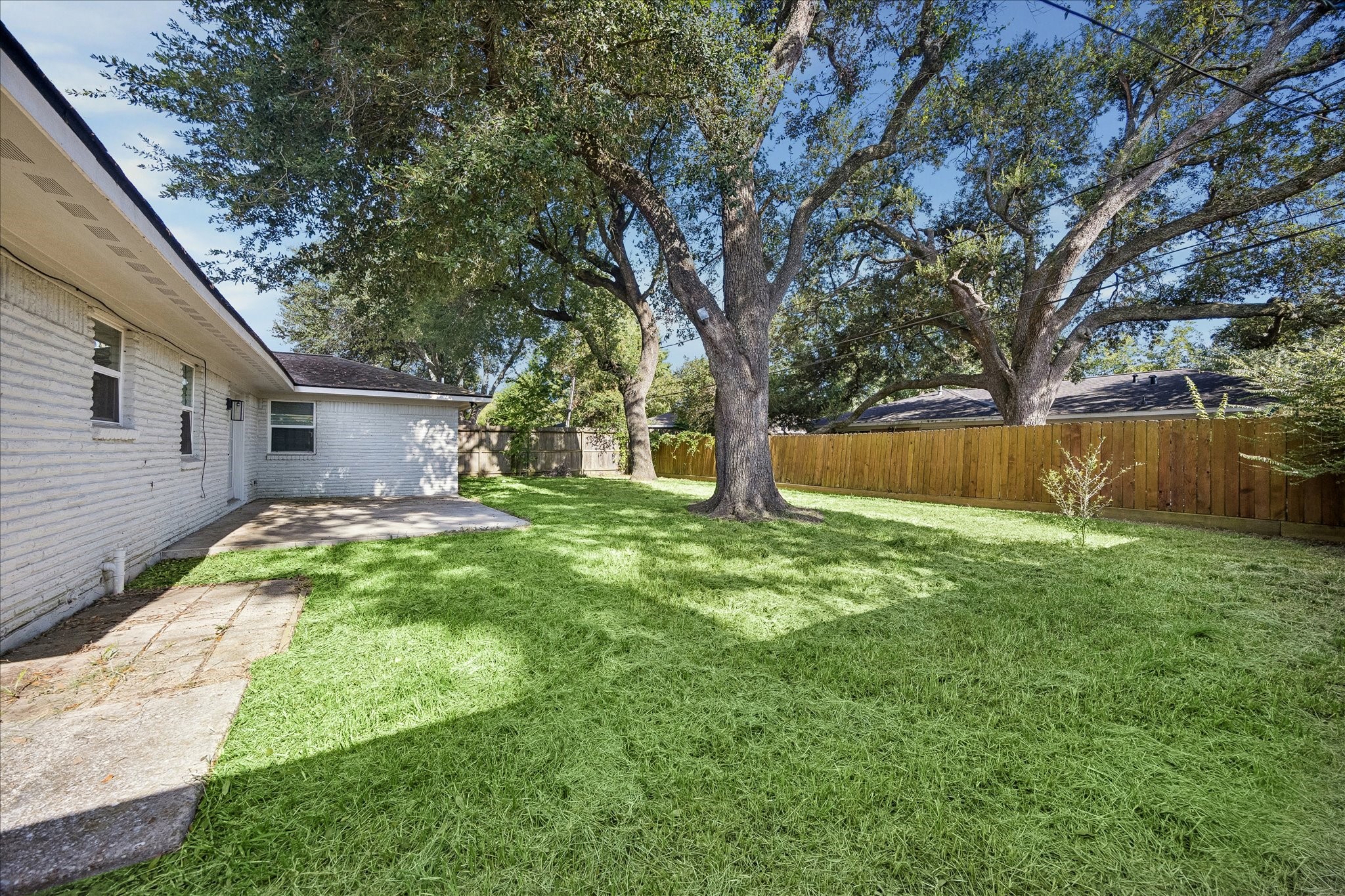 Huge fenced yard with mature trees & recent section of fencing.