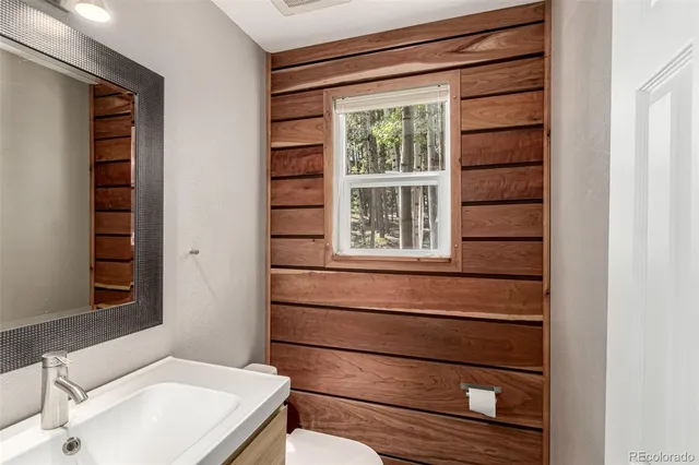 a bathroom with a granite countertop sink mirror and toilet