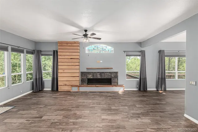 a view of an empty room with a fireplace and a window