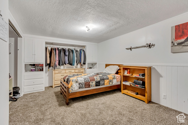 360 East Center Street Centerville, UT 84014 - Photo 39 of 41 Carpeted bedroom with a closet, a textured ceiling, and a wainscoted wall