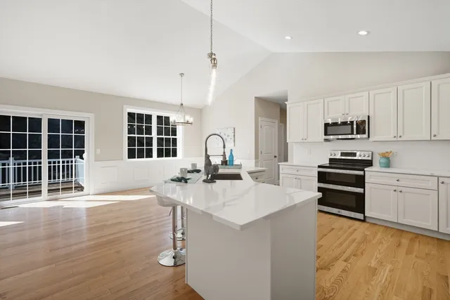 a kitchen with stainless steel appliances granite countertop a stove top oven a sink a counter space and cabinets