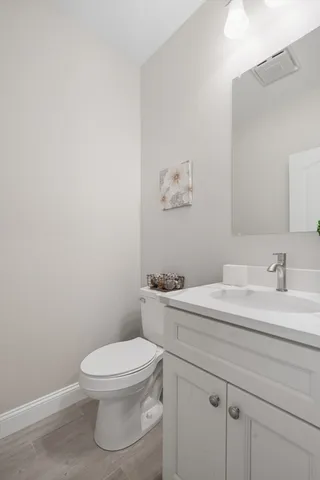 a bathroom with a toilet a sink and mirror