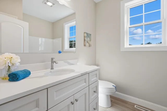 a bathroom with a toilet sink and mirror