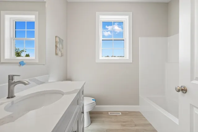 a bathroom with a sink a toilet and shower