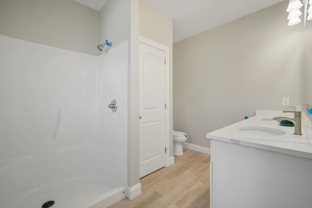 a bathroom with a sink a toilet and shower