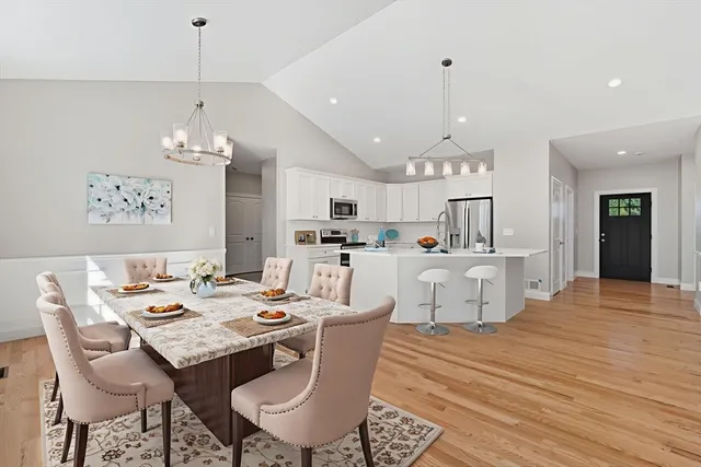 a dining room with stainless steel appliances kitchen island a table and chairs