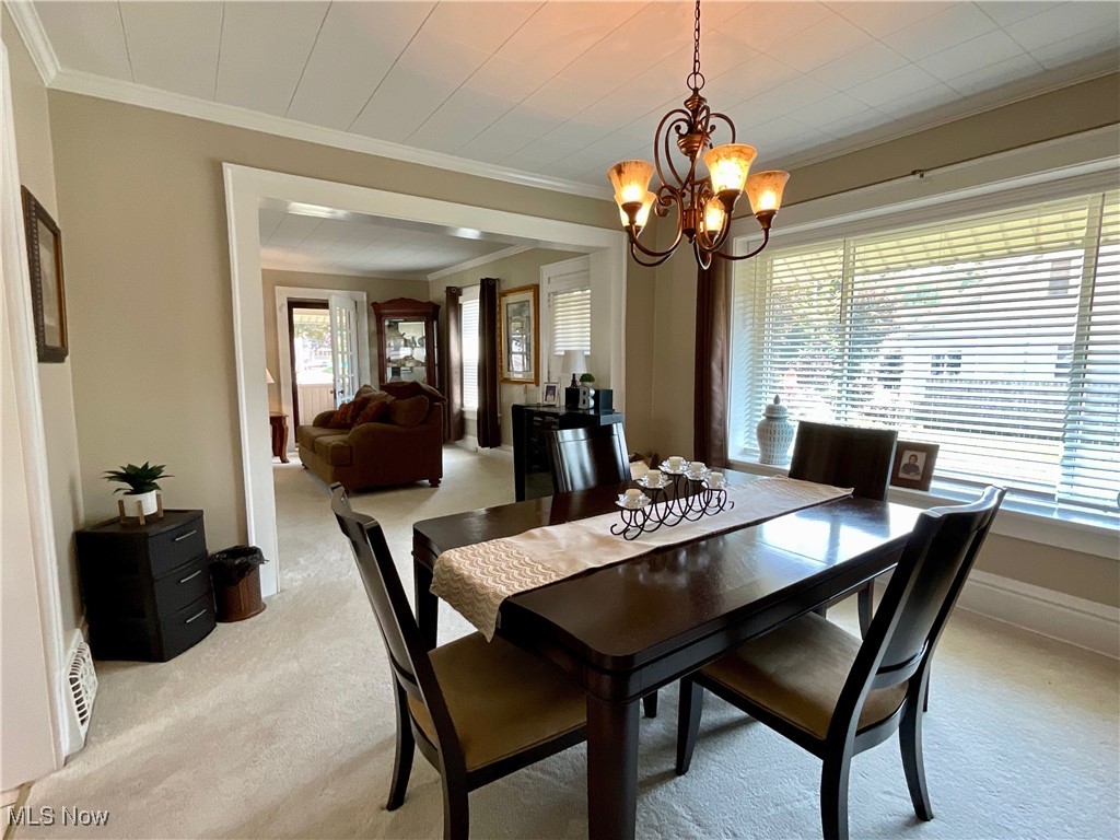 904 Chalker Street Akron, OH 44310 - Photo 3 of 28 Dining area with light carpet, plenty of natural light, ornamental molding, and a chandelier