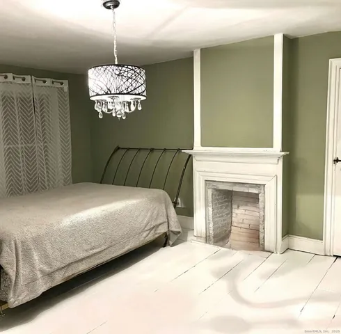 a bedroom with a bed and a fireplace