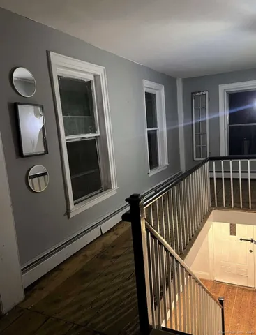 a view of staircase with railing and a window