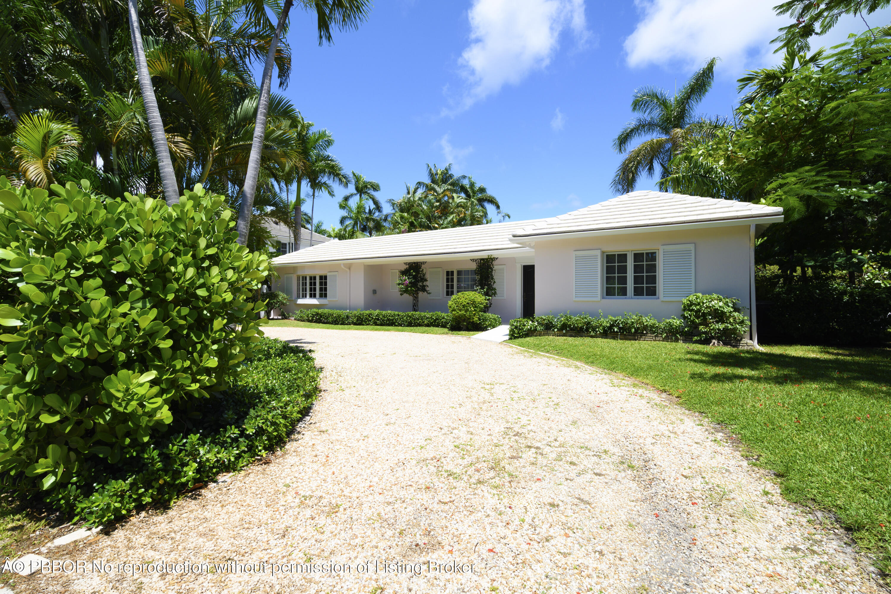 201 Pendleton Avenue Palm Beach, FL 33480 - Photo 2 of 22 a white house with a small yard plants and large trees