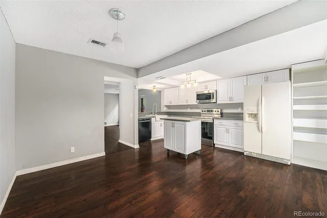 a kitchen with kitchen island white cabinets and stainless steel appliances
