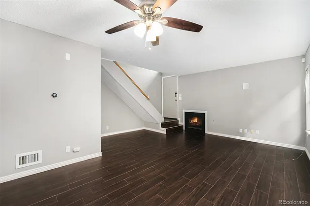 a view of a livingroom with wooden floor and a ceiling fan