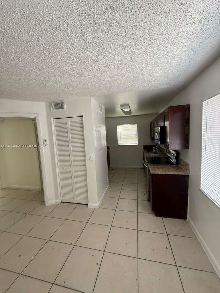 6921 Pembroke Road, Unit 6927 Pembroke Pines, FL 33023 - Photo 8 of 10 a view of a electric appliances in kitchen and empty room with wooden floor