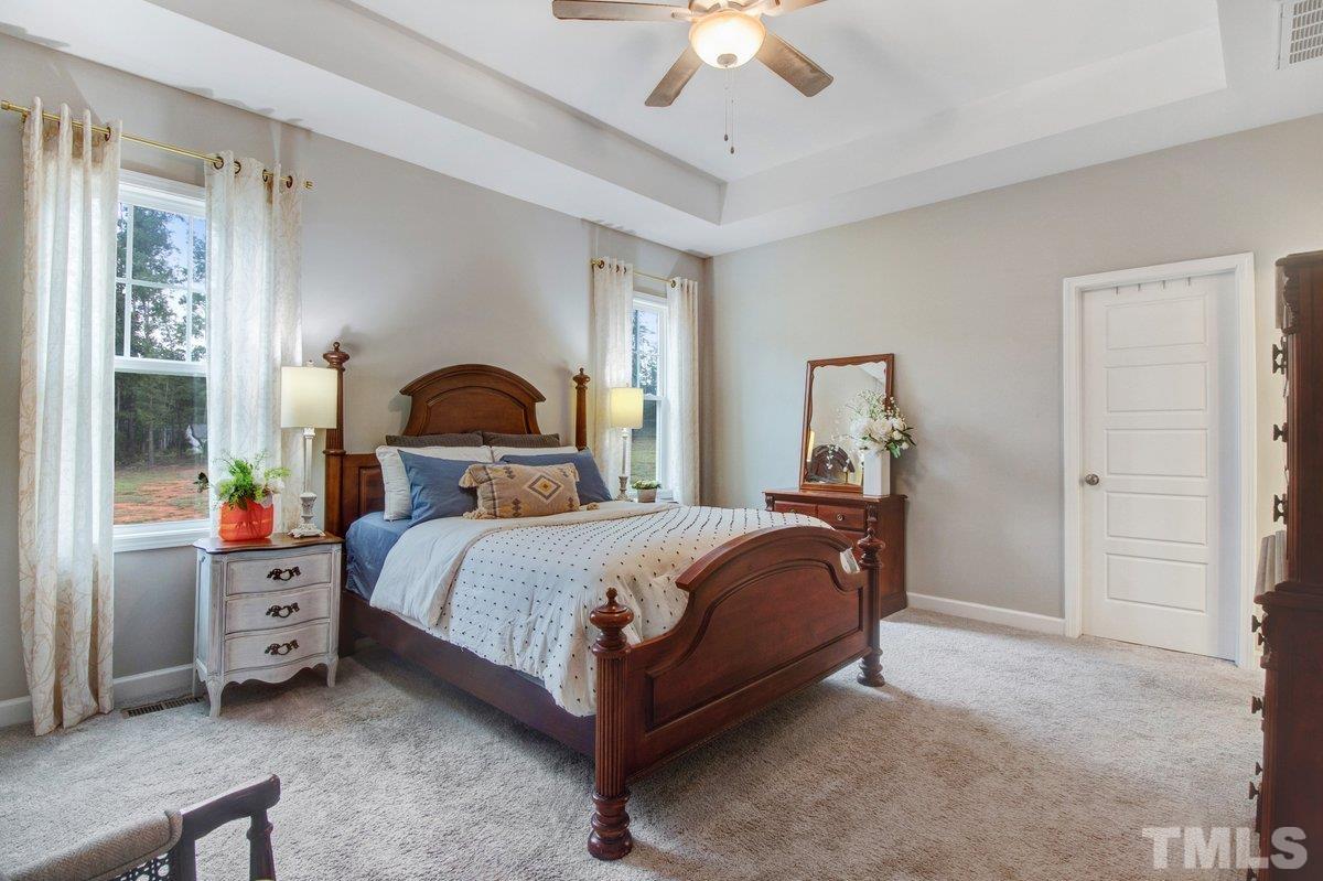 240 Northview Drive Middlesex, NC 27557 - Photo 21 of 40 a bedroom with a bed and a chandelier