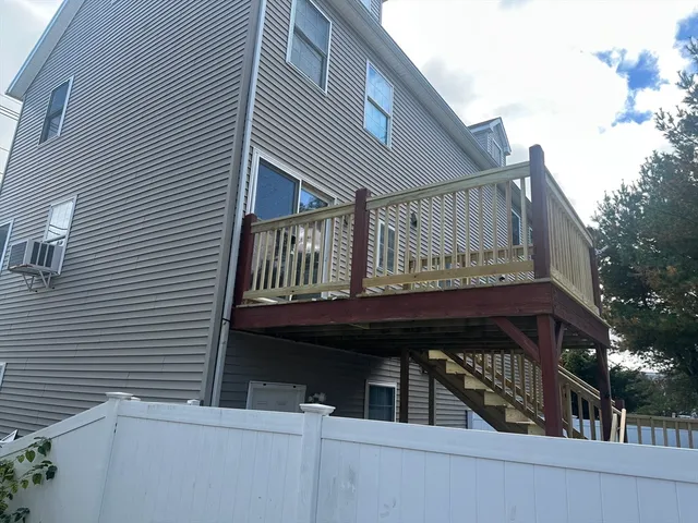 a view of a roof deck with wooden fence and floor