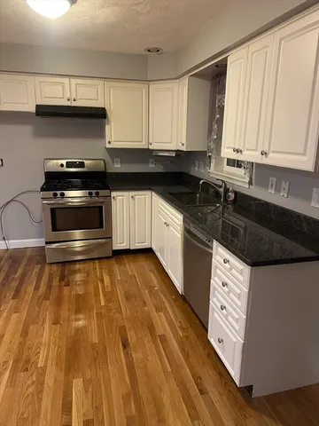a kitchen with granite countertop a sink and a stove