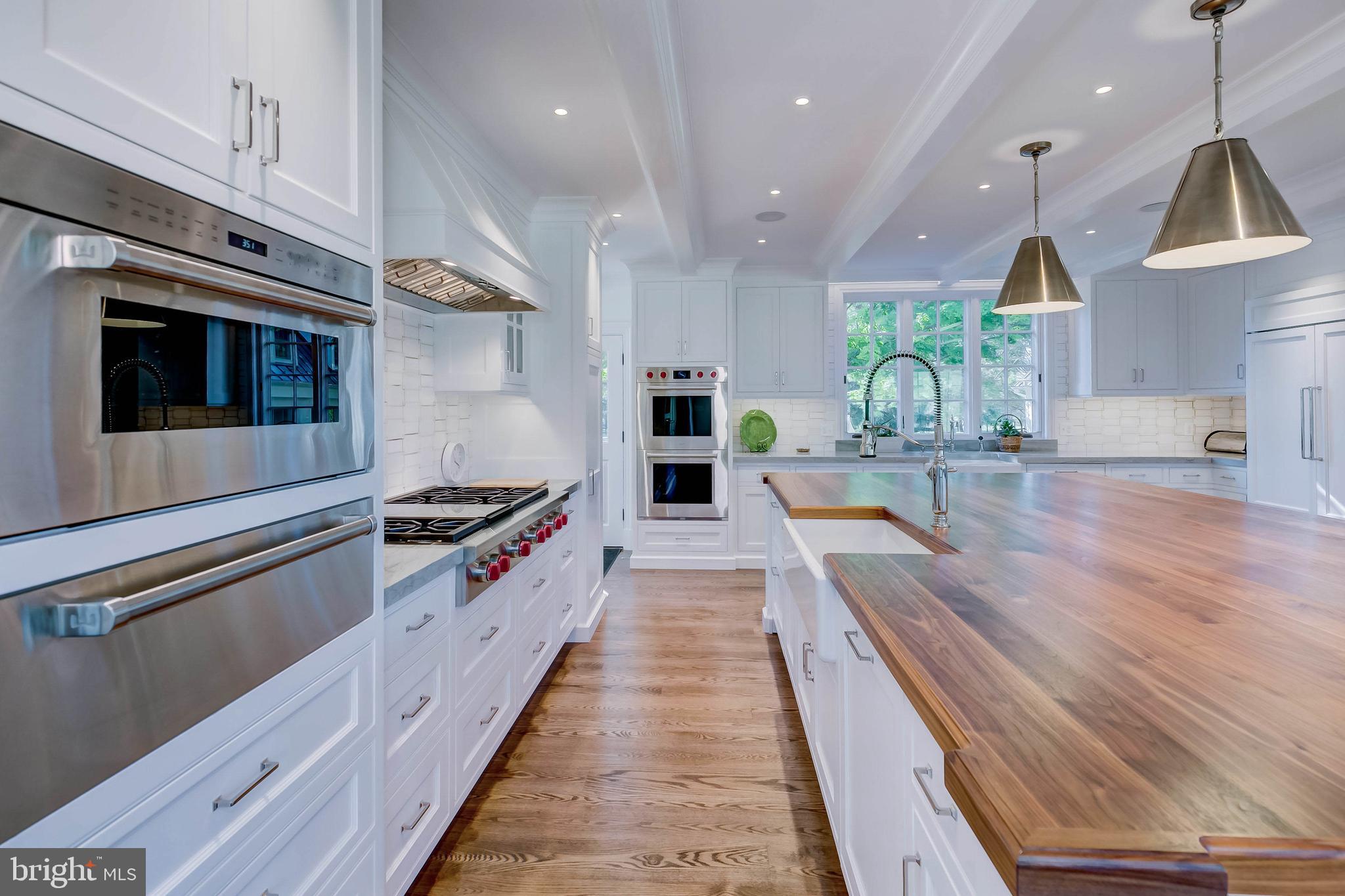 13401 Longnecker Road Reisterstown, MD 21136 - Photo 39 of 58 a white kitchen with wooden floor and stainless steel appliances