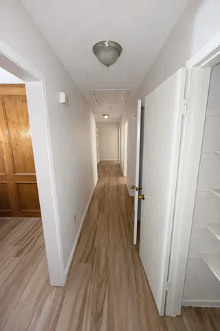 a view of a hallway with wooden floor and staircase