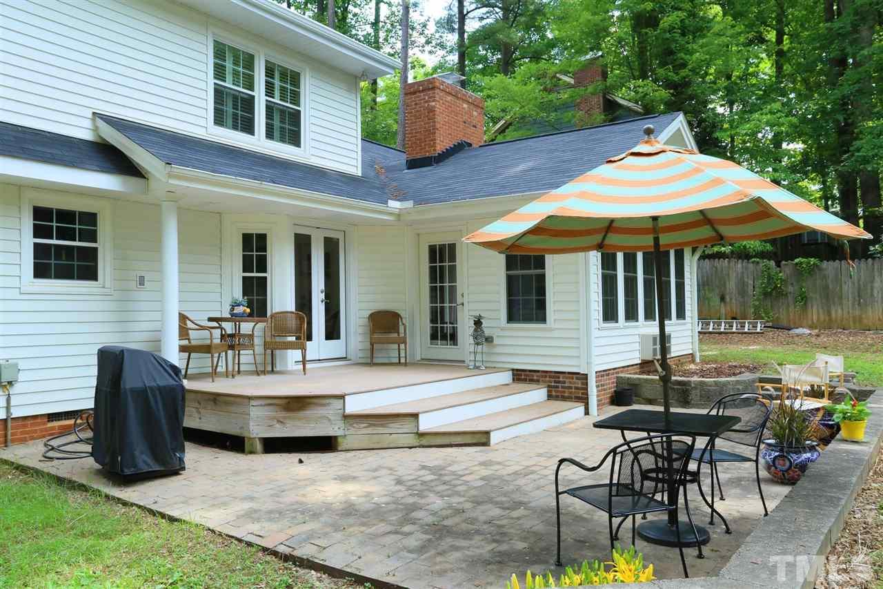 4505 Old Colony Road Raleigh, NC 27613 - Photo 2 of 30 a patio with a table and chairs under an umbrella