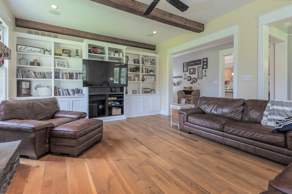 1915 Teague Store Road Somerville, TN 38068 - Photo 25 of 38 Living area featuring wood-finish flooring, exposed ceiling beams, built-in shelving, recessed lighting, and a ceiling fan