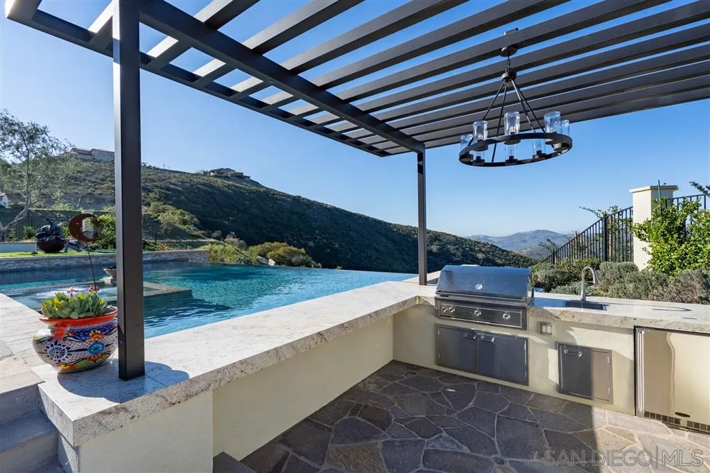8920 Via Rancho Cielo Rancho Santa Fe, CA 92067 - Photo 16 of 25 a open kitchen with stainless steel appliances granite countertop a sink and stove top oven