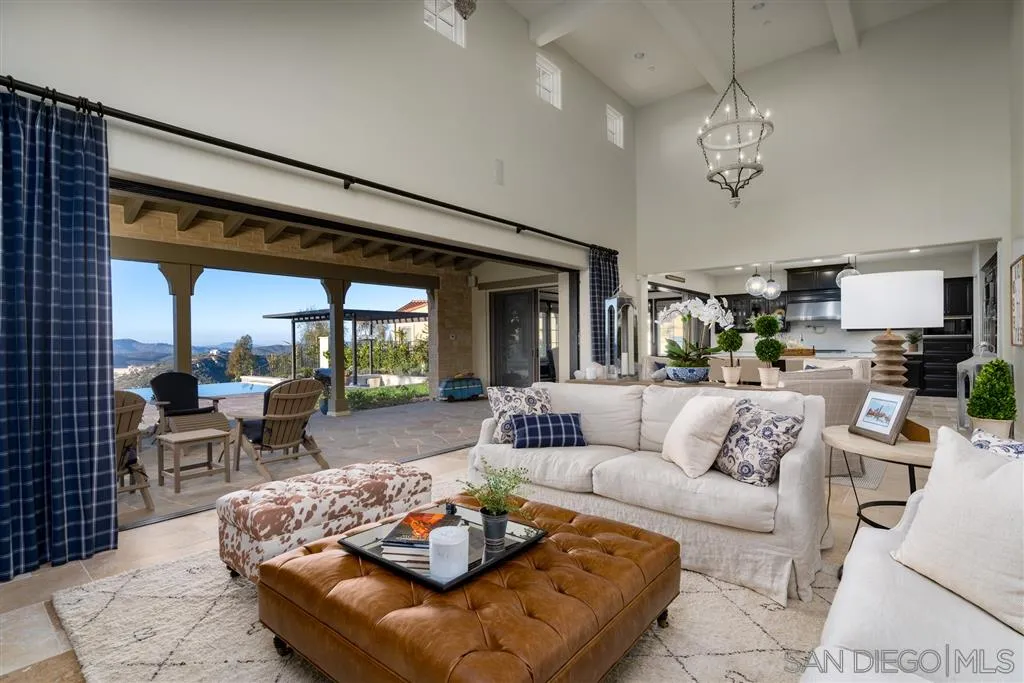 8920 Via Rancho Cielo Rancho Santa Fe, CA 92067 - Photo 3 of 25 a living room with furniture chandelier and a large window