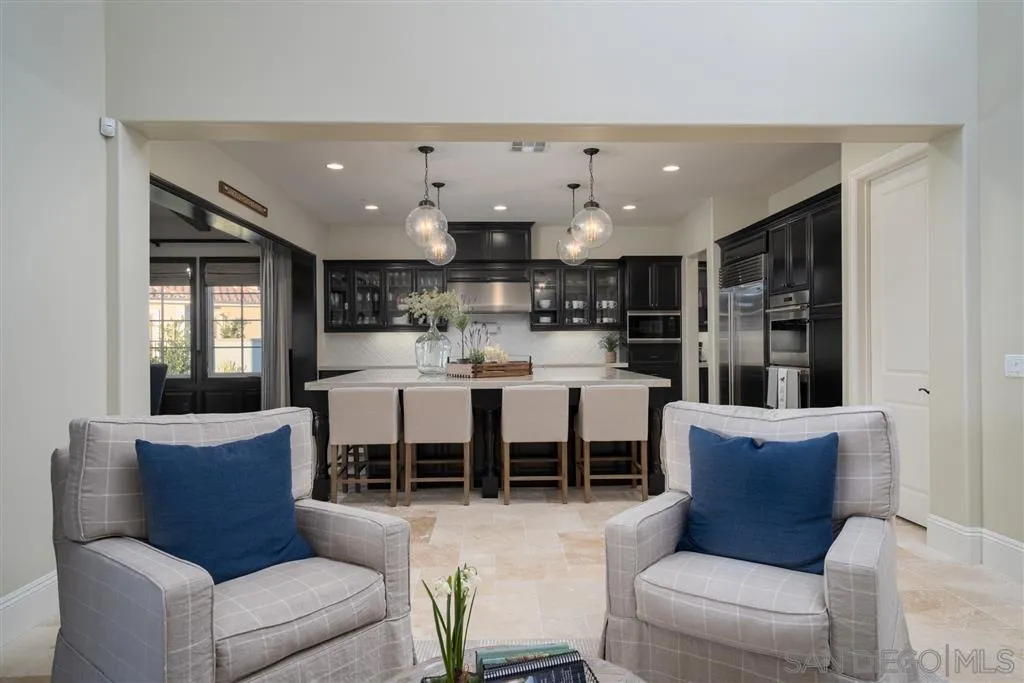 8920 Via Rancho Cielo Rancho Santa Fe, CA 92067 - Photo 5 of 25 a living room with furniture wooden floor and a kitchen view