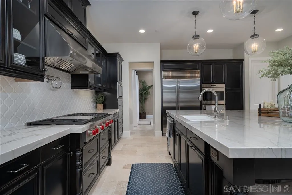 8920 Via Rancho Cielo Rancho Santa Fe, CA 92067 - Photo 7 of 25 a kitchen with kitchen island granite countertop a sink stainless steel appliances and cabinets