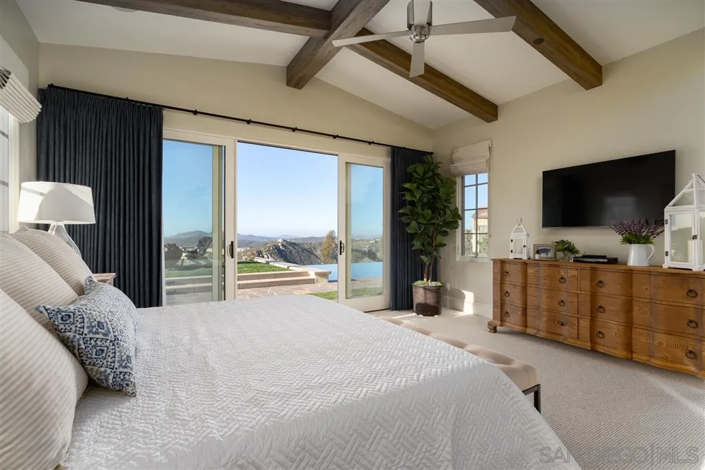 8920 Via Rancho Cielo Rancho Santa Fe, CA 92067 - Photo 9 of 25 a bedroom with a bed and a flat tv screen on dresser