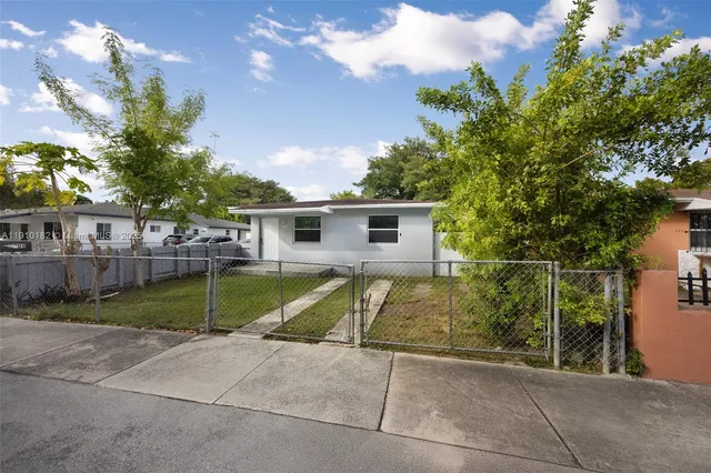 a view of backyard with swimming pool and seating space