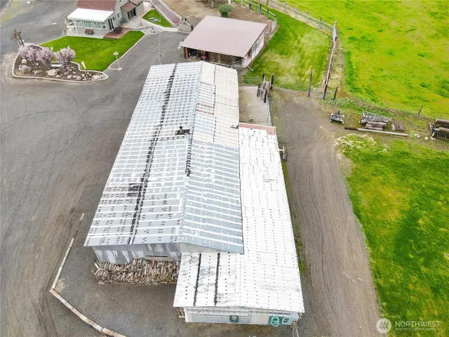 an aerial view of a house with a yard and a large tree