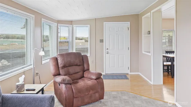 a living room with furniture a dining table and chairs with wooden floor