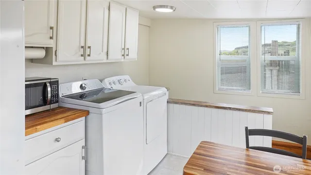 a kitchen with granite countertop white cabinets and white appliances