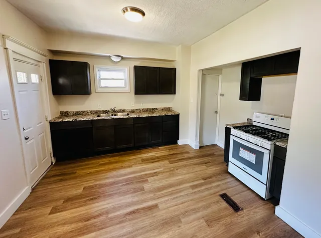 a view of kitchen with sink microwave and refrigerator
