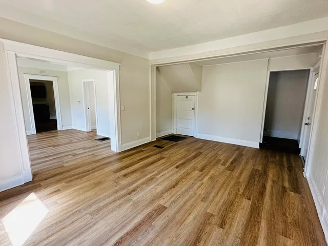 a view of a room with wooden floor and a bathroom