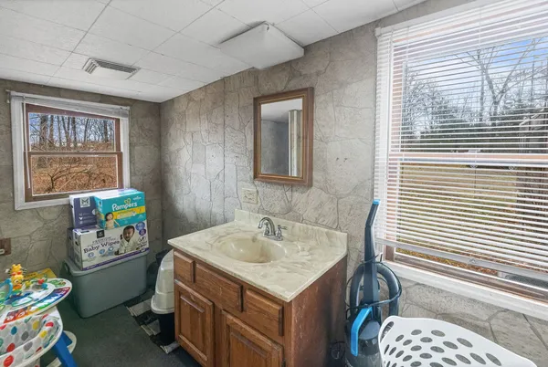 a bathroom with a sink a toilet and a window