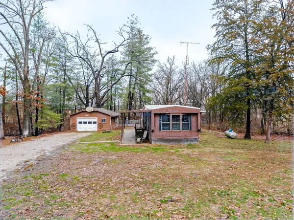 a front view of a house with a garden and trees