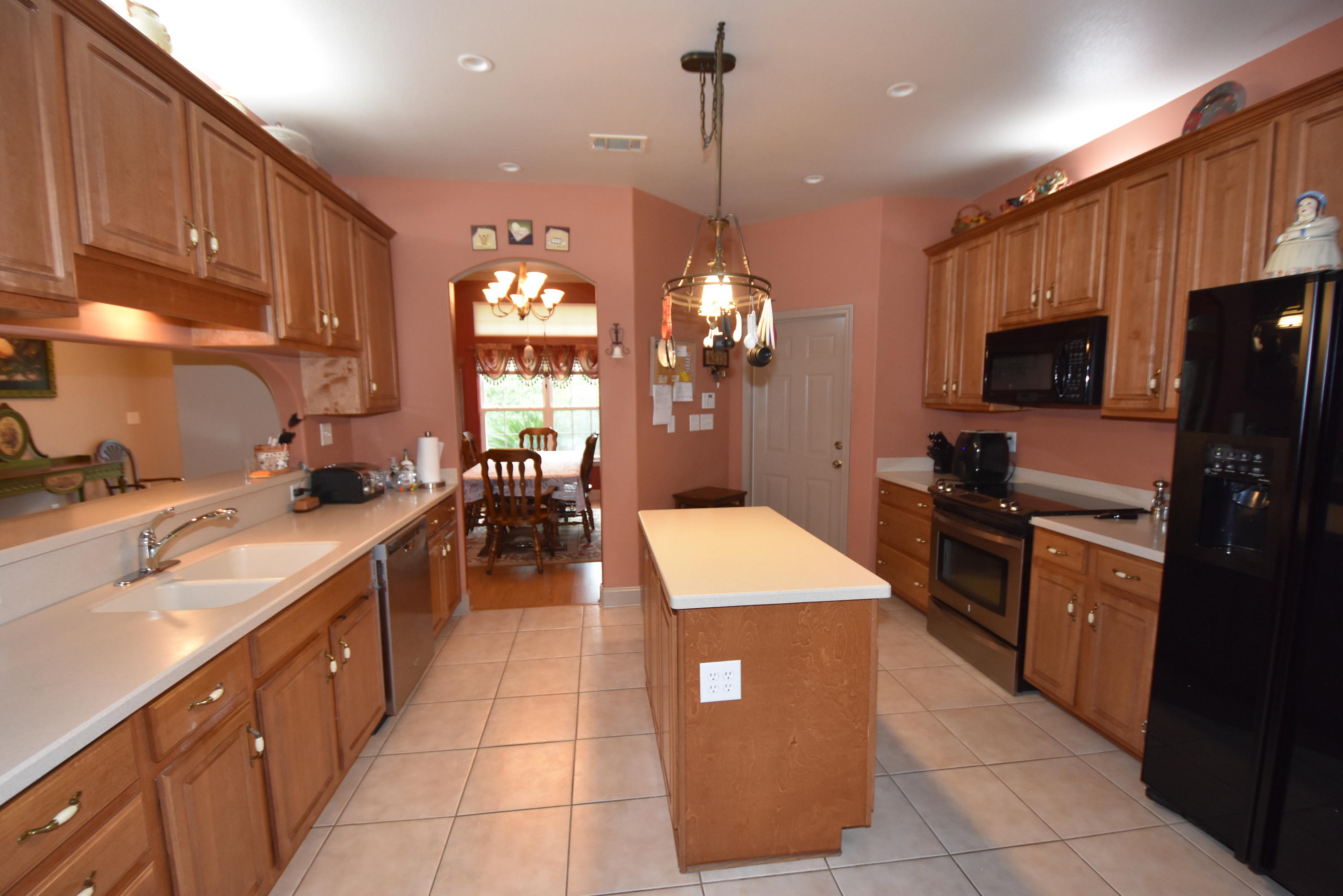 6000 Gagnon Road Crestview, FL 32539 - Photo 14 of 51 a kitchen with stainless steel appliances kitchen island granite countertop a sink counter space cabinets and a view of living room