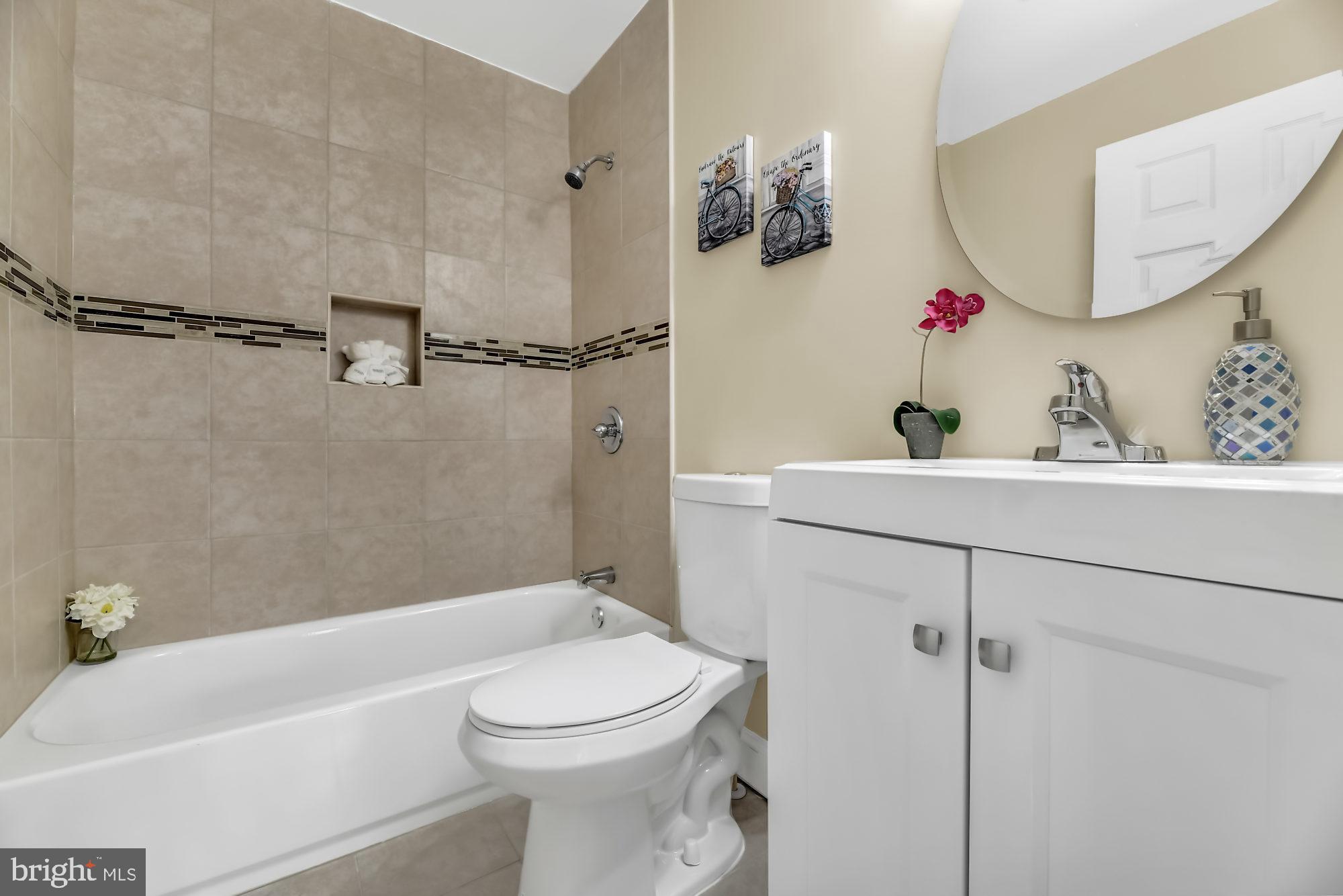 3713 Cassen Road Randallstown, MD 21133 - Photo 21 of 27 a bathroom with a sink a mirror a toilet and bathtub