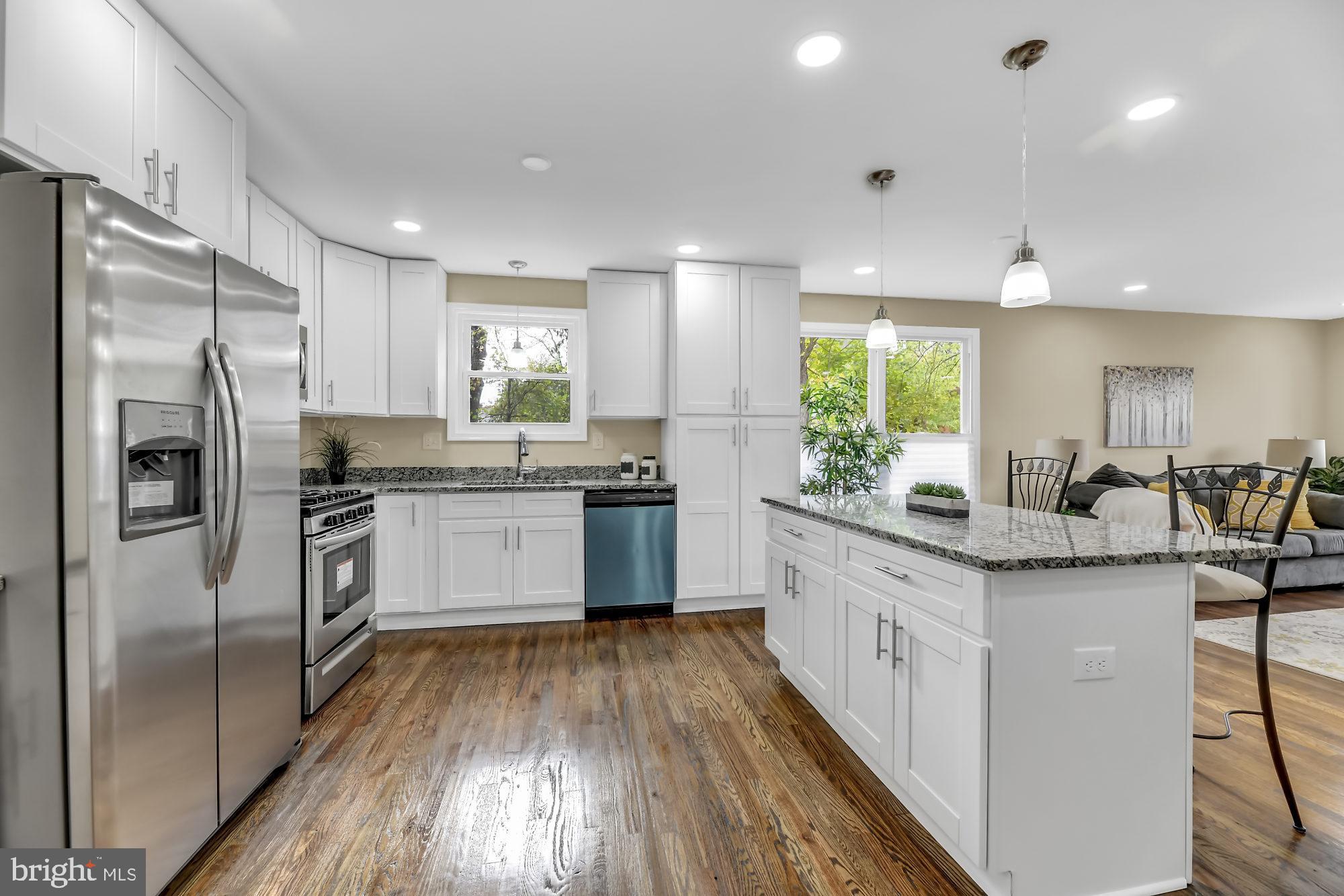 3713 Cassen Road Randallstown, MD 21133 - Photo 8 of 27 a kitchen with stainless steel appliances granite countertop a stove a sink dishwasher a refrigerator and white cabinets with wooden floor