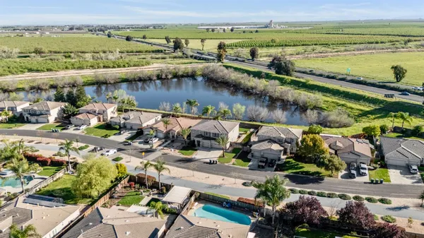 an aerial view of residential houses with outdoor space and trees